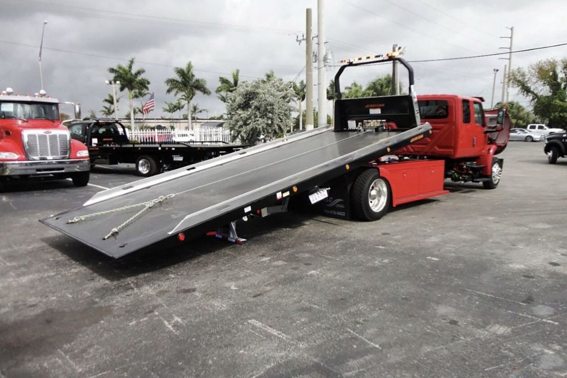 Professional flatbed tow truck transporting vehicle safely in Elmhurst, IL