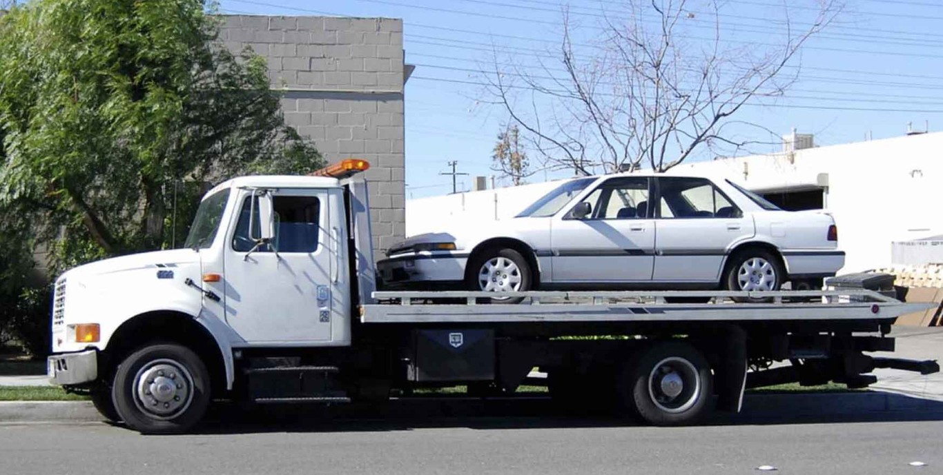 Flatbed towing service transporting a sedan safely in Elmhurst, IL